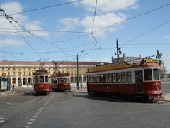 Rote Touristenbahnen am Praça do Comércio 